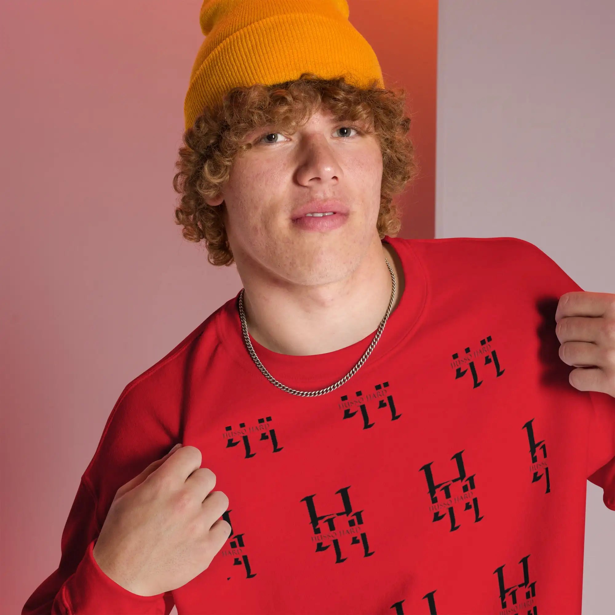 Man wearing red Husso Hard all-over print sweatshirt with yellow beanie