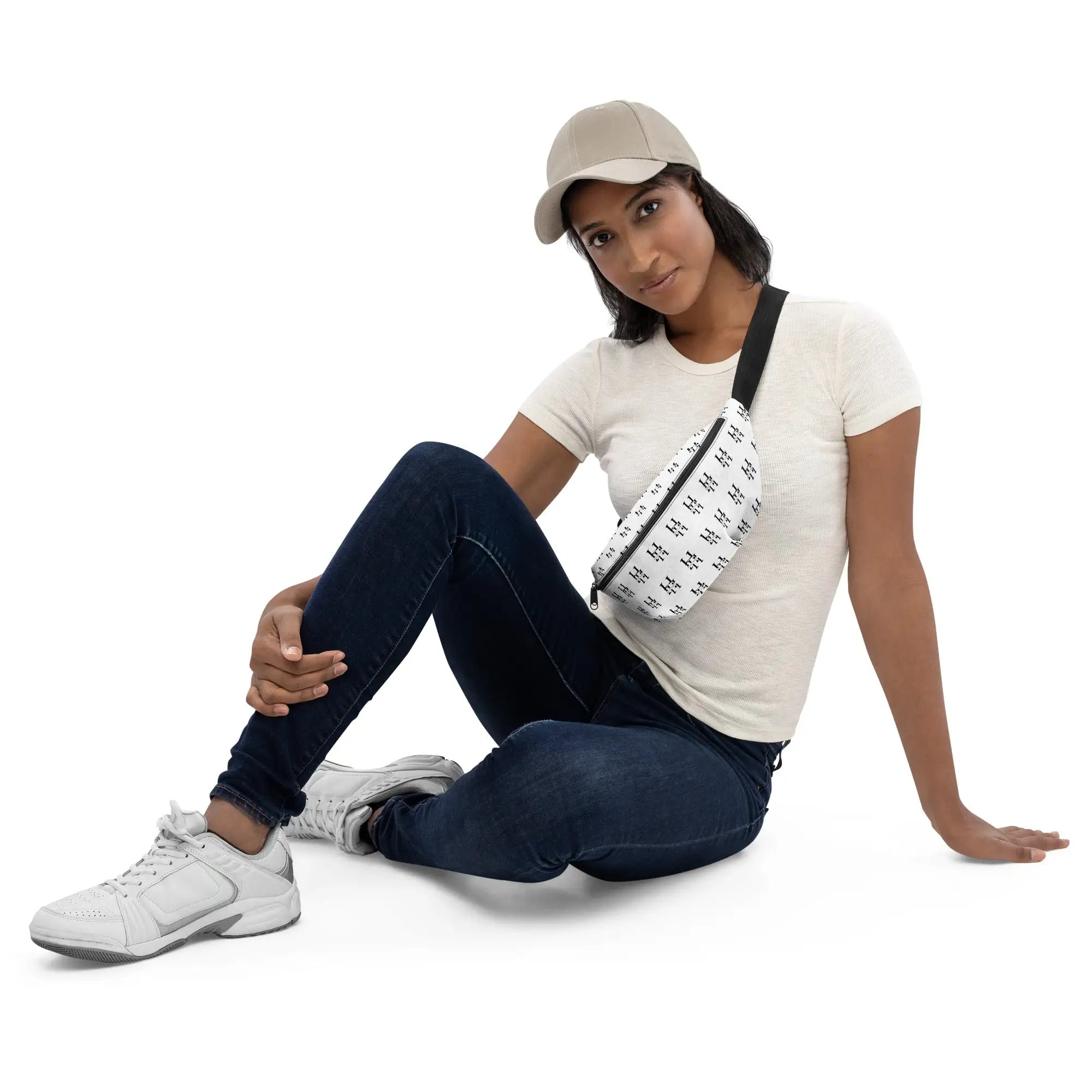 Woman wearing white Husso Hard crossbody bag with beige cap, white top, and blue jeans