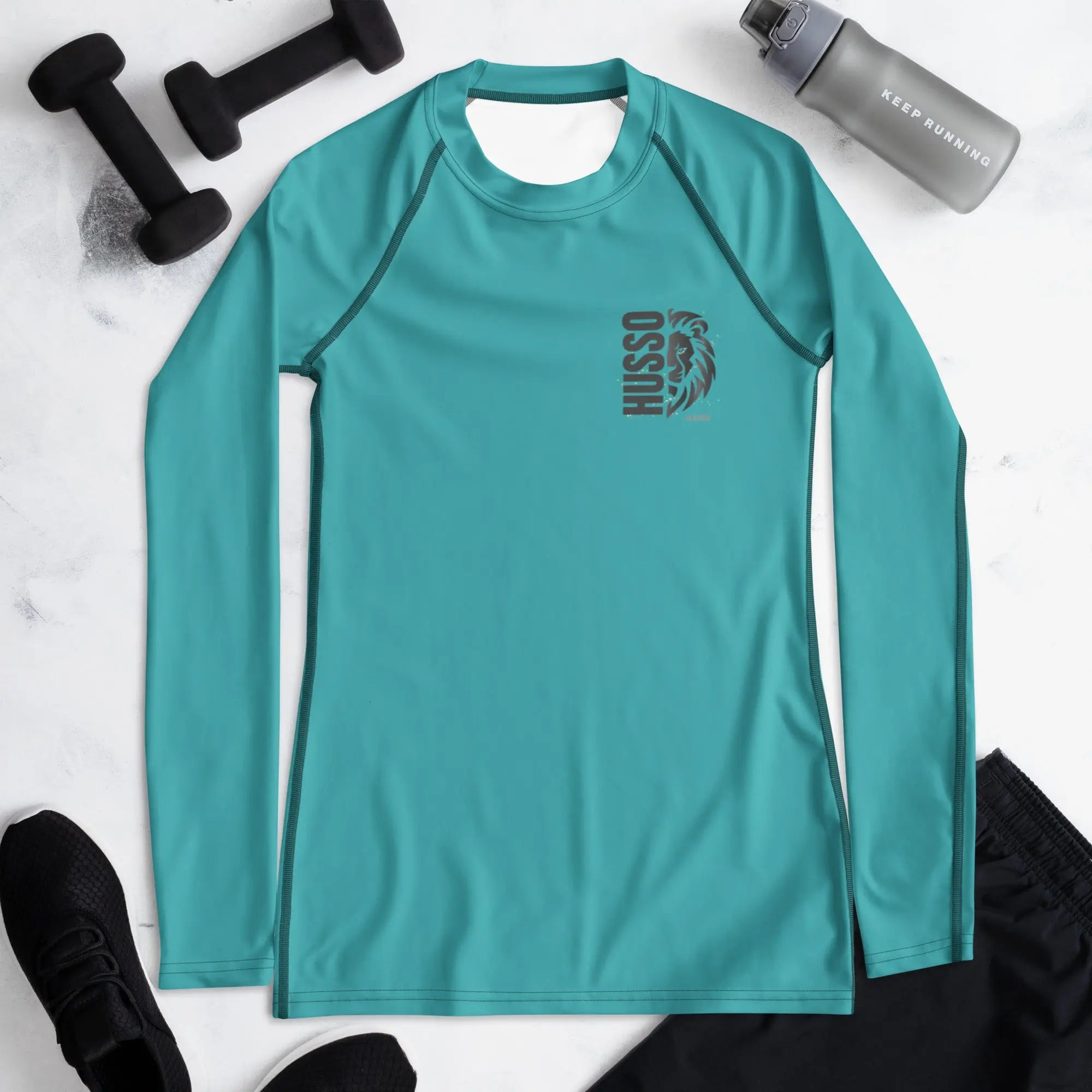 Teal Husso Hard long sleeve athletic rash guard flat lay with gym accessories