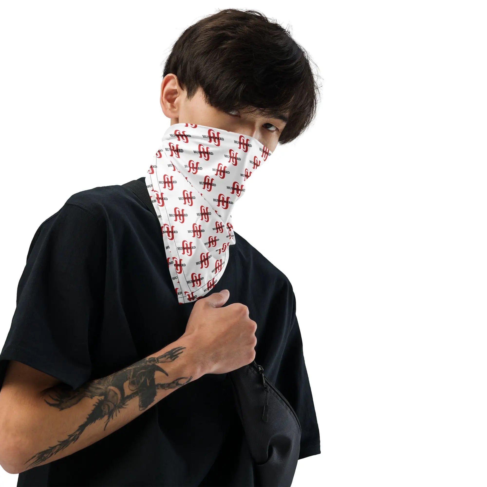 Man wearing white Husso Hard logo neck gaiter with black t-shirt and crossbody bag