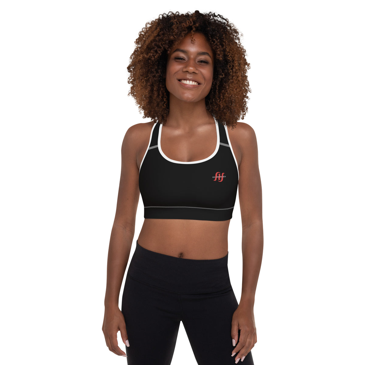 Woman wearing black Husso Hard padded sports bra with white trim and red logo, front view