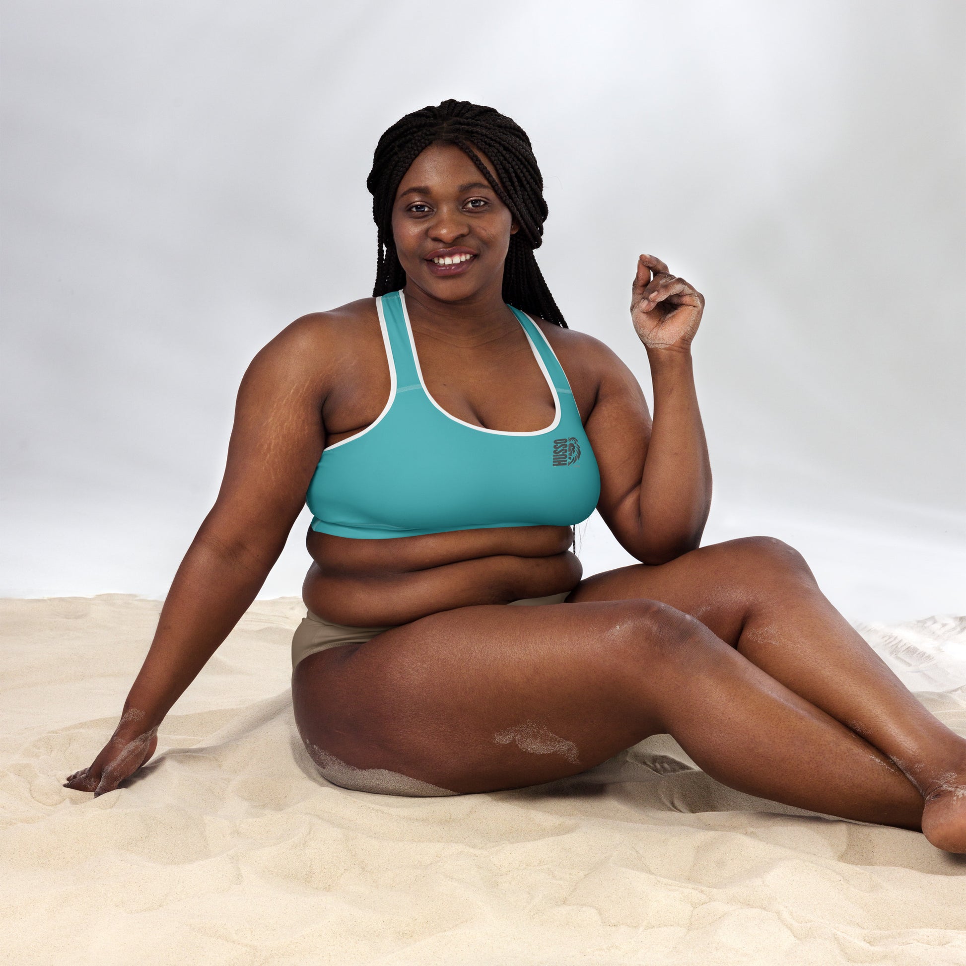Woman wearing blue Husso Hard padded sports bra, seated view